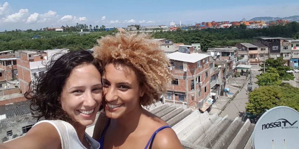 Selfie de Monica e Marielle com a favela da Maré ao fundo